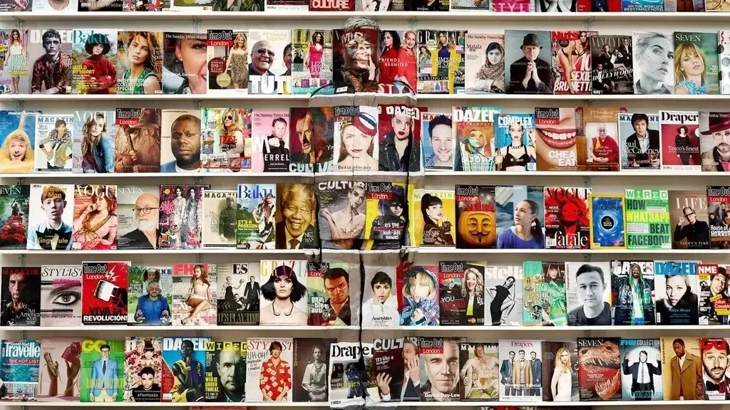 Liu Bolin, painted to match a newsagent’s shelves of magazine covers, almost invisible in the middle of the picture